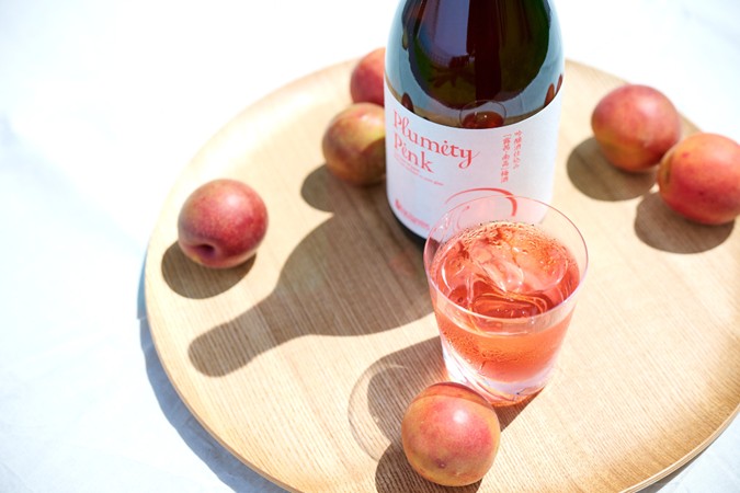 木製プレートに置かれたワインとプラム